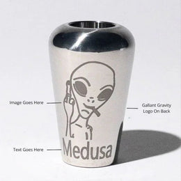 Stainless steel gravity bong bowl with engraved alien design and 'Medusa' text on front.