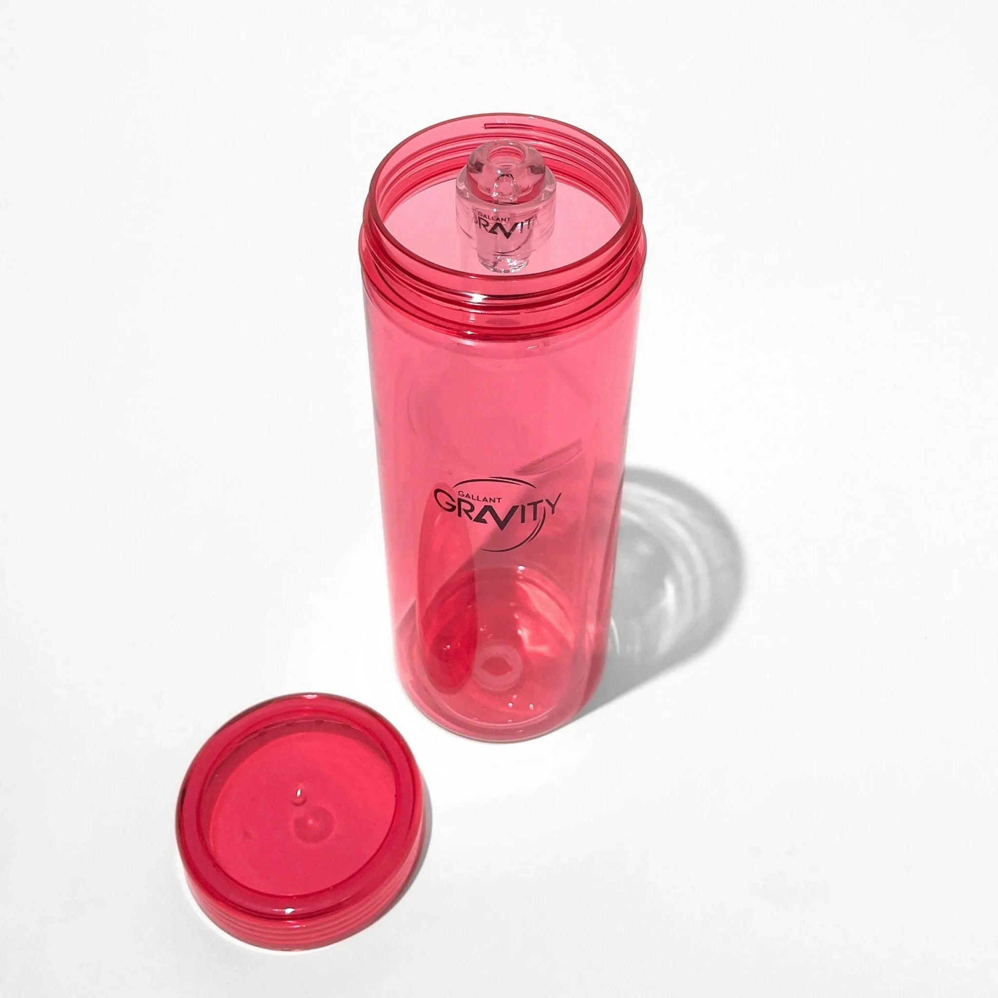 Pink glass gravity bong chamber with removable lid on white background